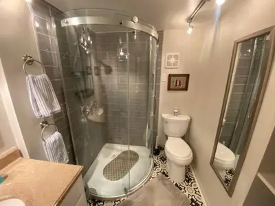 a bathroom with a shower and a toilet and a sink at Adorable Buckeye Lake Cottage in Buckeye Lake
