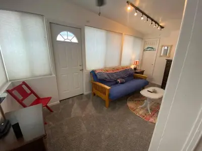 a living room with a blue couch and a table at Adorable Buckeye Lake Cottage in Buckeye Lake