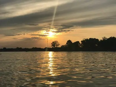 a sunset over a large body of water at Adorable Buckeye Lake Cottage in Buckeye Lake