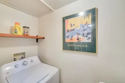a laundry room with a poster on the wall at Peaceful Hiram Retreat on Cuyahoga River! in Aurora