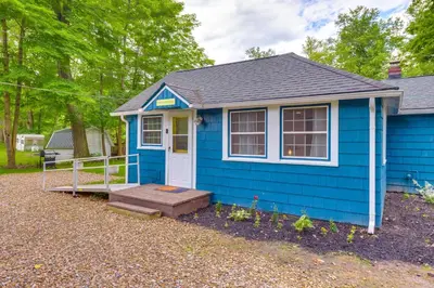 a blue tiny house with a porch at Peaceful Hiram Retreat on Cuyahoga River! in Aurora