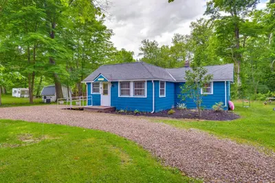 a blue house in the middle of a yard at Peaceful Hiram Retreat on Cuyahoga River! in Aurora