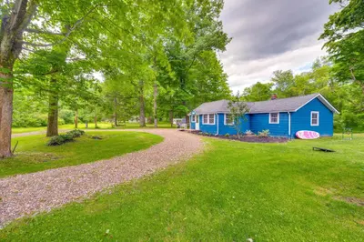 a blue house in the middle of a green yard at Peaceful Hiram Retreat on Cuyahoga River! in Aurora