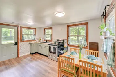 a kitchen with wooden floors and a table with chairs at Peaceful Hiram Retreat on Cuyahoga River! in Aurora