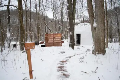 a cabin in the woods in the snow at Mohican Hideaway in Brinkhaven