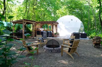 a backyard with a tent and chairs and a fire pit at Mohican Hideaway in Brinkhaven