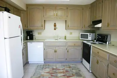a kitchen with wooden cabinets and a white refrigerator at Portage Lakes Serenity in Akron