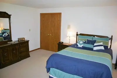 a bedroom with a bed and a dresser and a mirror at Portage Lakes Serenity in Akron