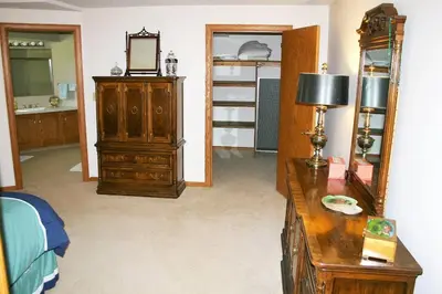 a room with a bedroom with a dresser and a mirror at Portage Lakes Serenity in Akron