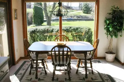 a dining room table with chairs and a window at Portage Lakes Serenity in Akron