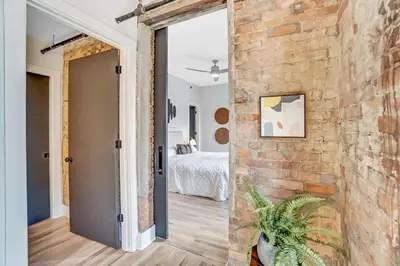 an open door to a bedroom with a brick wall at Vaughn Lofts # 4 in Cincinnati