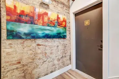 a brick wall with a painting on it next to a door at Vaughn Lofts # 4 in Cincinnati