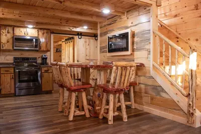a log cabin kitchen with a table and chairs at Hickory Ridge Cabin+Fire pit in Ewing