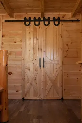 a large wooden door in a room with wooden walls at Hickory Ridge Cabin+Fire pit in Ewing