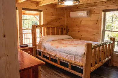 a bedroom with a bed in a log cabin at Hickory Ridge Cabin+Fire pit in Ewing