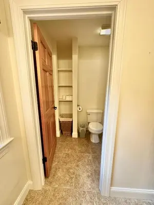 a small bathroom with a toilet and a door at Redbud Retreat in Centerville