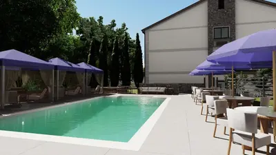 a swimming pool with blue umbrellas and tables and chairs at The Wave at Marblehead in Marblehead
