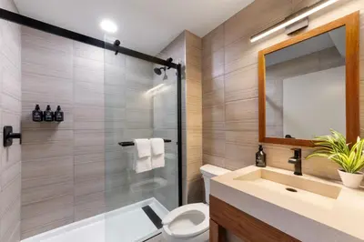 a bathroom with a toilet and a sink and a mirror at The Wave at Marblehead in Marblehead