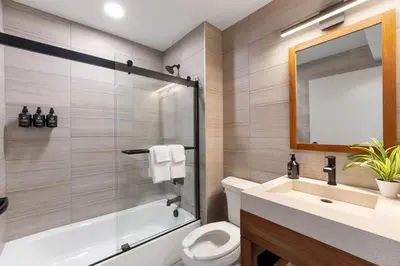 a bathroom with a tub and a sink and a toilet at The Wave at Marblehead in Marblehead