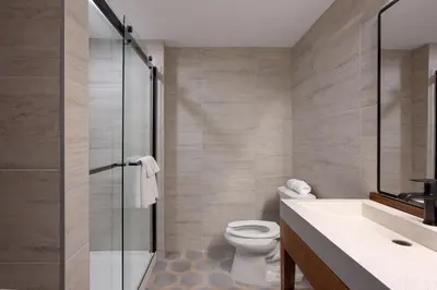 a bathroom with a toilet and a glass shower at The Wave at Marblehead in Marblehead