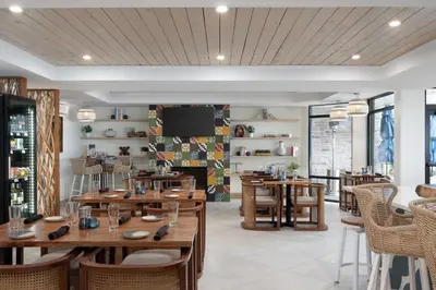 a restaurant with wooden tables and chairs at The Wave at Marblehead in Marblehead