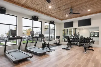 a gym with treadmills and elliptical machines and windows at The Wave at Marblehead in Marblehead