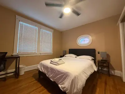 a bedroom with a bed with white sheets and a window at Stay with Jay - Segunda Room in Cleveland