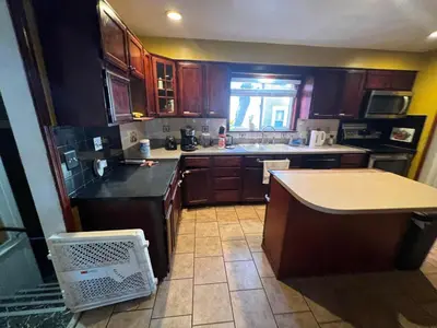 a kitchen with wooden cabinets and a counter top at Stay with Jay - Segunda Room in Cleveland
