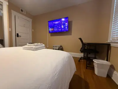 a bedroom with a bed with a tv on the wall at Stay with Jay - Segunda Room in Cleveland