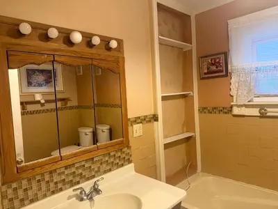 a bathroom with a sink and a tub and a mirror at Stay with Jay - Segunda Room in Cleveland