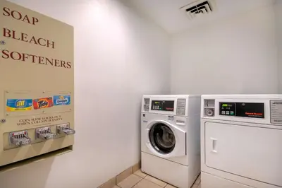 a laundry room with a washing machine and a sign at Motel 6 Walton, KY - Richwood - Cincinnati Airport South in Walton