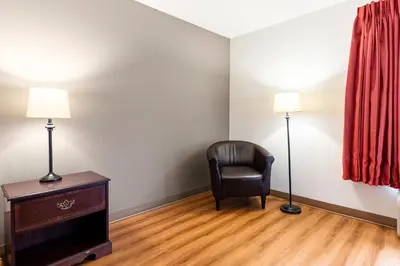 a room with a chair and a desk and lamp at Motel 6 Walton, KY - Richwood - Cincinnati Airport South in Walton