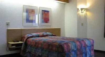 a hotel room with a bed and two pictures on the wall at Hotel Markle IN I-69 in Markle