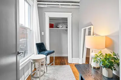a living room with a blue chair and a table at 1BR - Walk to Convention Center & Stadiums in Ludlow