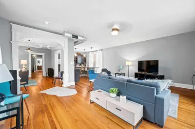 a living room with a blue couch and a tv at 1BR - Walk to Convention Center & Stadiums in Ludlow