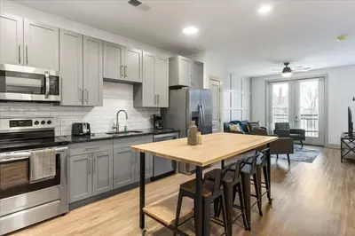 a kitchen with a wooden table and a dining room at 2 Stylish apartments near shops and entertainment in Cincinnati