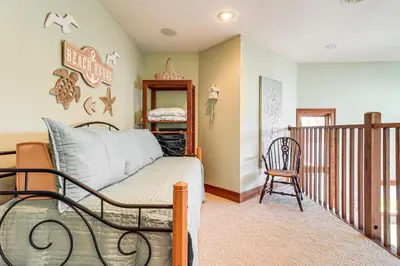 a bedroom with a bed and a chair in a room at Great Lake Erie Getaway with Hot Tub and Private Beach in Avalon Beach