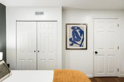 a bedroom with two white doors and a painting on the wall at 4 Bed 3 bath Boutique Home Near OSU, Crew Stadium, Short North, COSI, & Downtown in Columbus