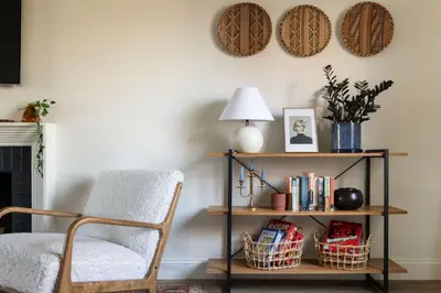 a living room with a chair and a shelf with books at 4 Bed 3 bath Boutique Home Near OSU, Crew Stadium, Short North, COSI, & Downtown in Columbus