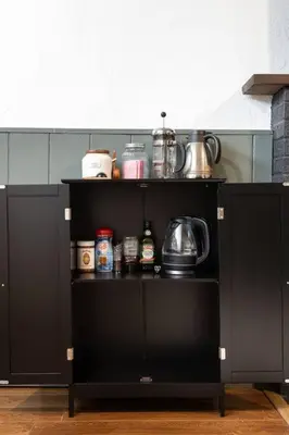 a black cabinet in a kitchen with food on it at 4 Bed 3 bath Boutique Home Near OSU, Crew Stadium, Short North, COSI, & Downtown in Columbus