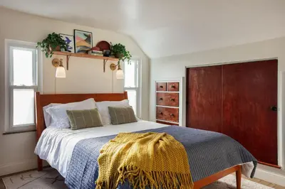 a bedroom with a bed with a blue and yellow blanket at 4 Bed 3 bath Boutique Home Near OSU, Crew Stadium, Short North, COSI, & Downtown in Columbus
