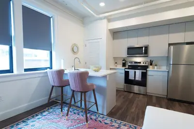 a kitchen with a counter and two bar stools at The Standard Downtown Columbus in Columbus