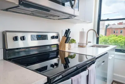 a kitchen with a stove top oven next to a sink at The Standard Downtown Columbus in Columbus