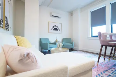 a living room with a white couch and chairs at The Standard Downtown Columbus in Columbus