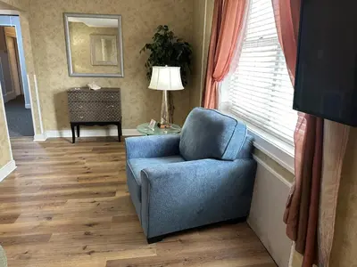 a blue chair sitting in a room with a window at Island House Historic Vacation Rentals in Port Clinton