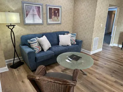 a living room with a blue couch and a table at Island House Historic Vacation Rentals in Port Clinton