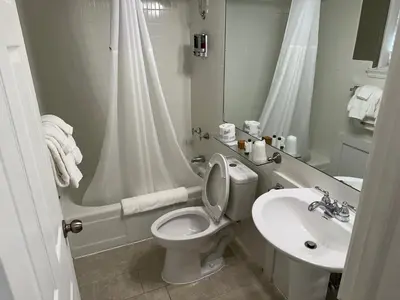 a white bathroom with a toilet and a sink at Island House Historic Vacation Rentals in Port Clinton