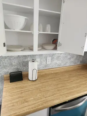 a kitchen counter with white cabinets and white bowls at FC Suites in Cincinnati