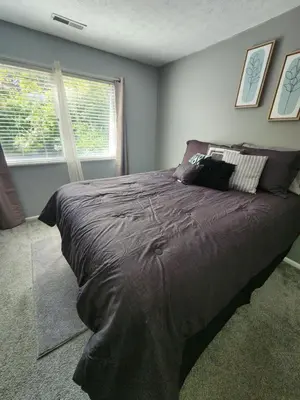 a large bed in a bedroom with a window at FC Suites in Cincinnati