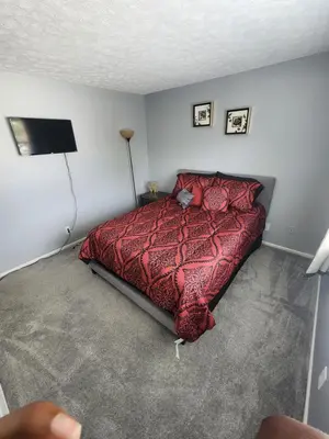 a bedroom with a bed with a red comforter at FC Suites in Cincinnati